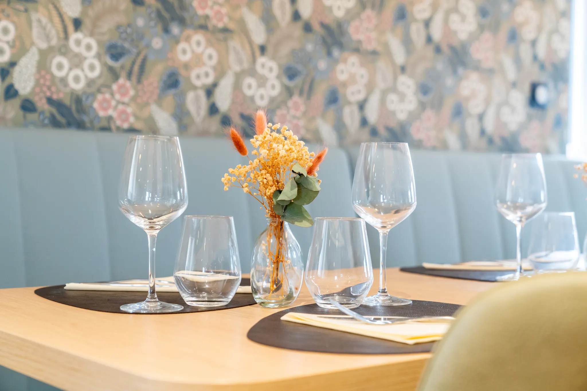 Verres et fleurs séchées sur le papier peint floral