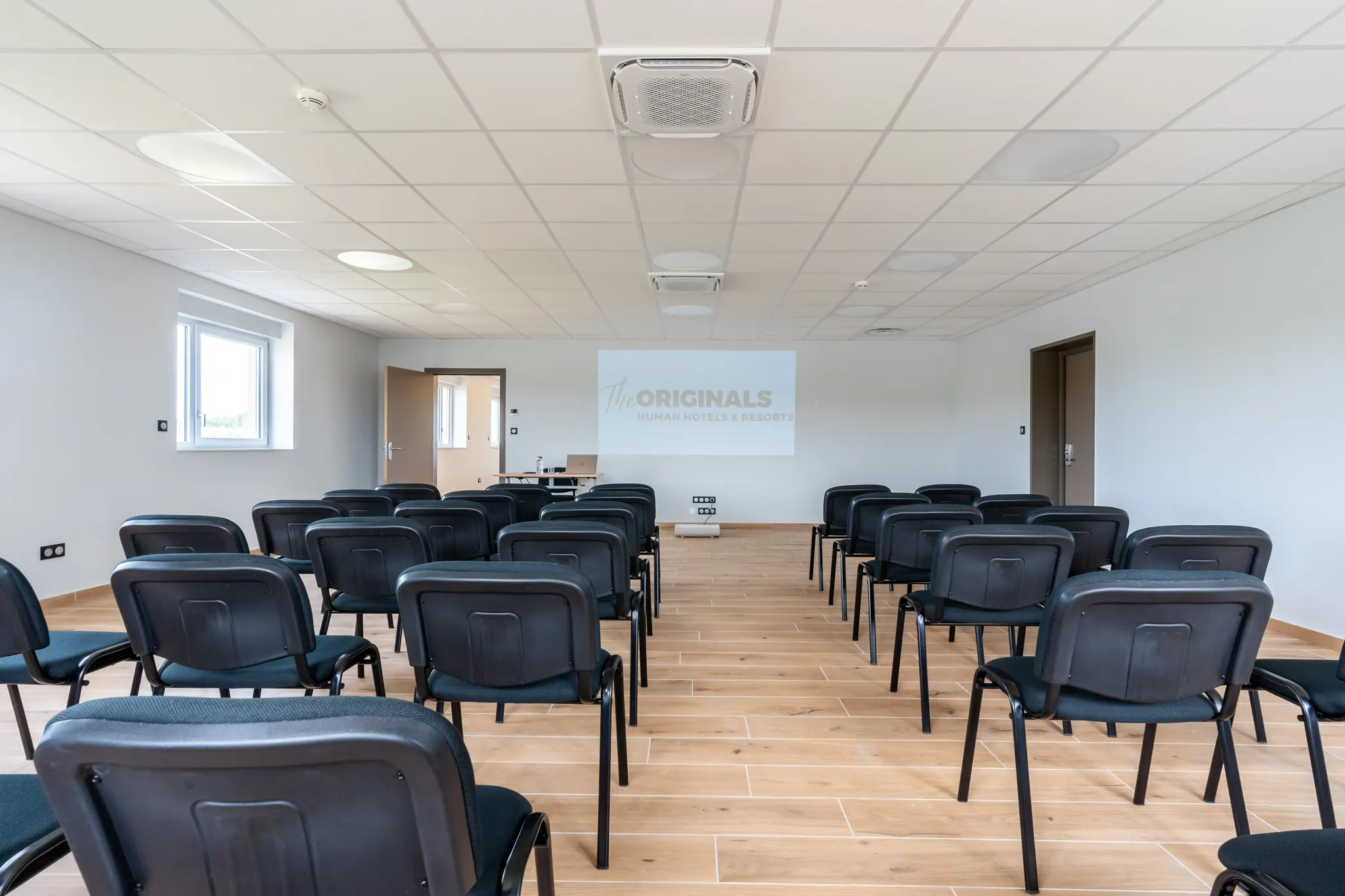 La salle de séminaire en disposition théâtre, écran projeté