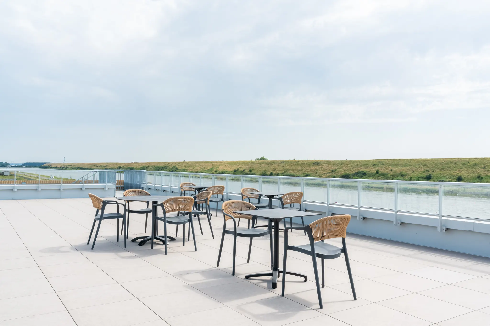 La terrasse et ses tables, face au bassin