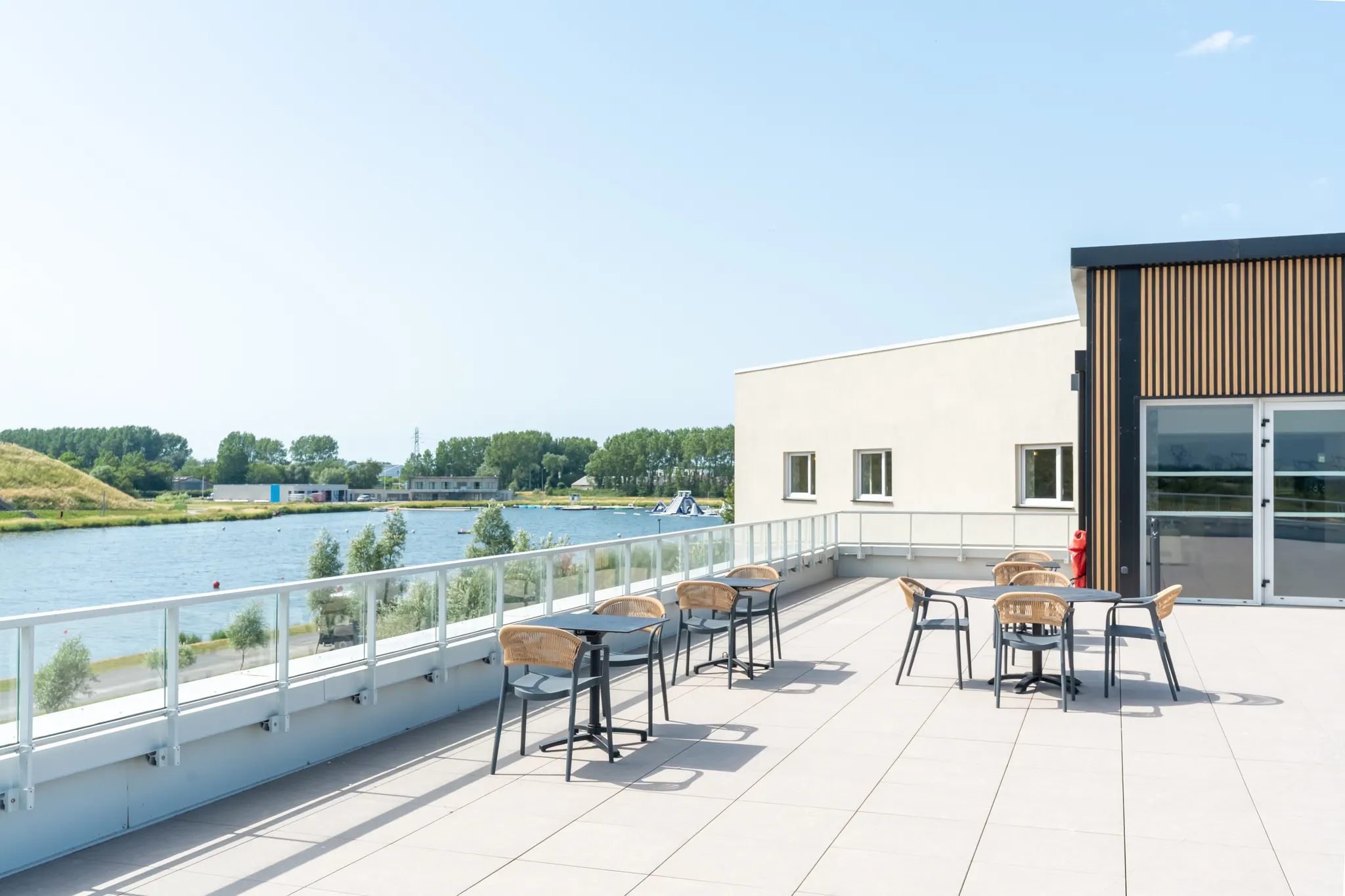 La terrasse le long du bâtiment, ouverte sur l'eau